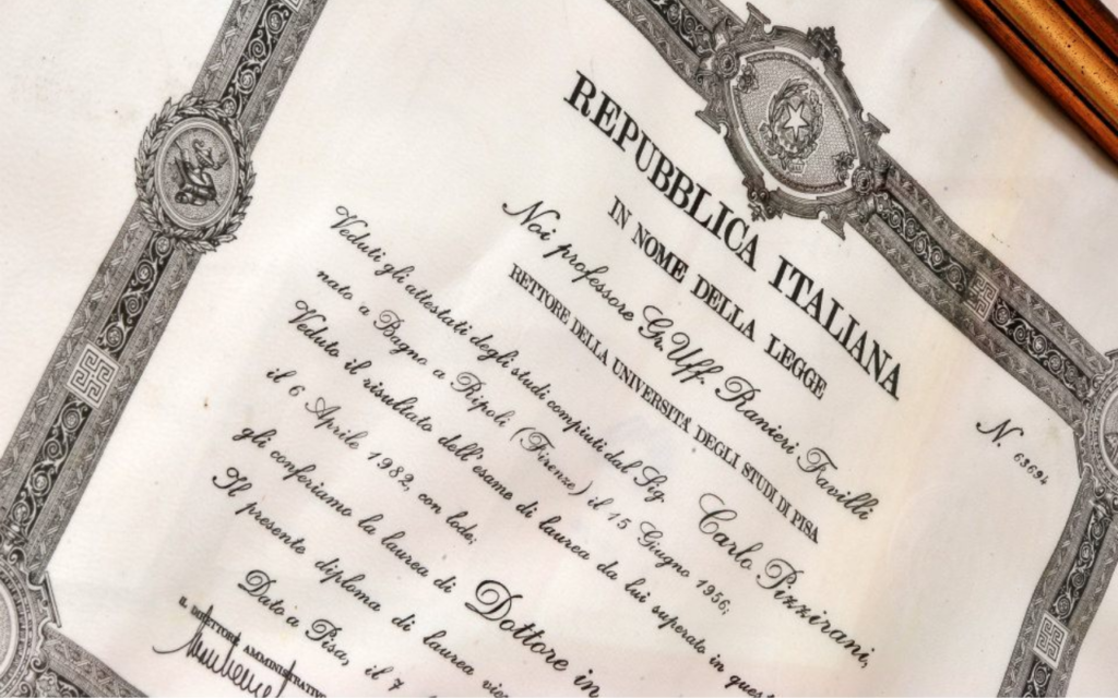 Primo piano di un diploma universitario italiano ornato da bordi decorativi, sigilli ufficiali ed elegante testo scritto in italiano, con l'intestazione Repubblica Italiana e il nome del laureato.